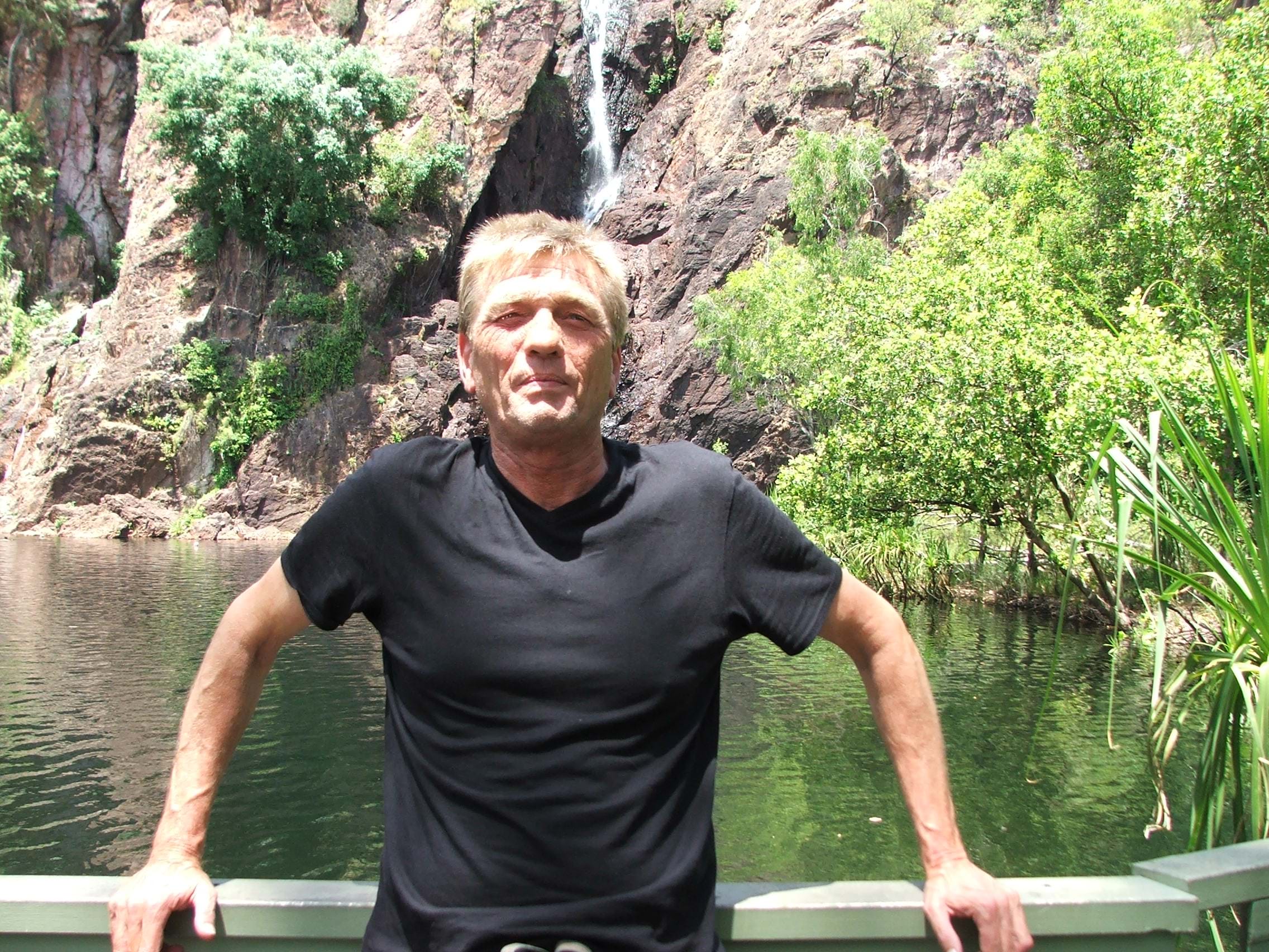 man in black t shirt surrounded by green scenery